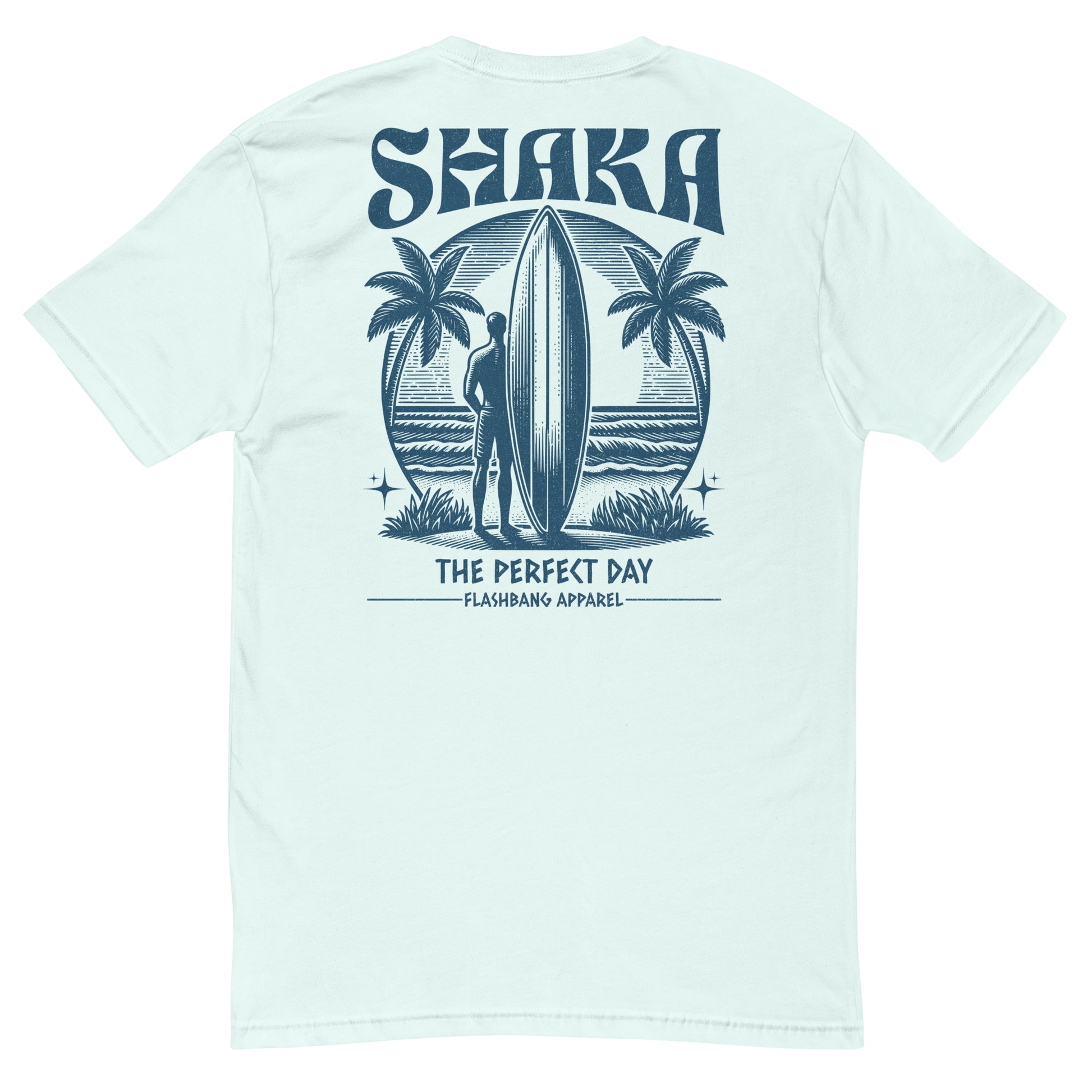 Light blue t-shirt with a graphic of a person holding a surfboard and palm trees, featuring the word 'Shaka' on a white background.