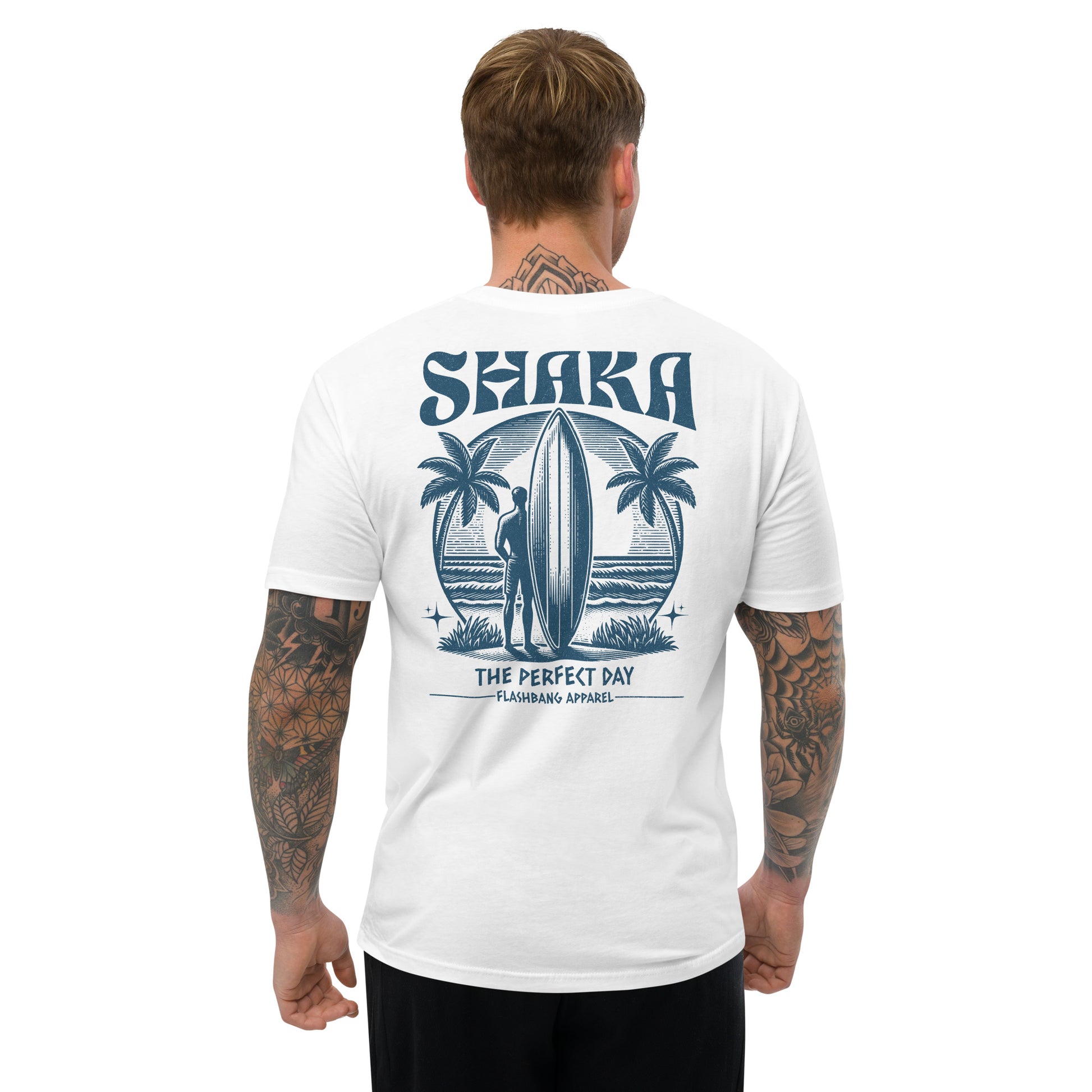 Man wearing a white t-shirt with a 'Shaka' design on the back, featuring palm trees and a surfboard.