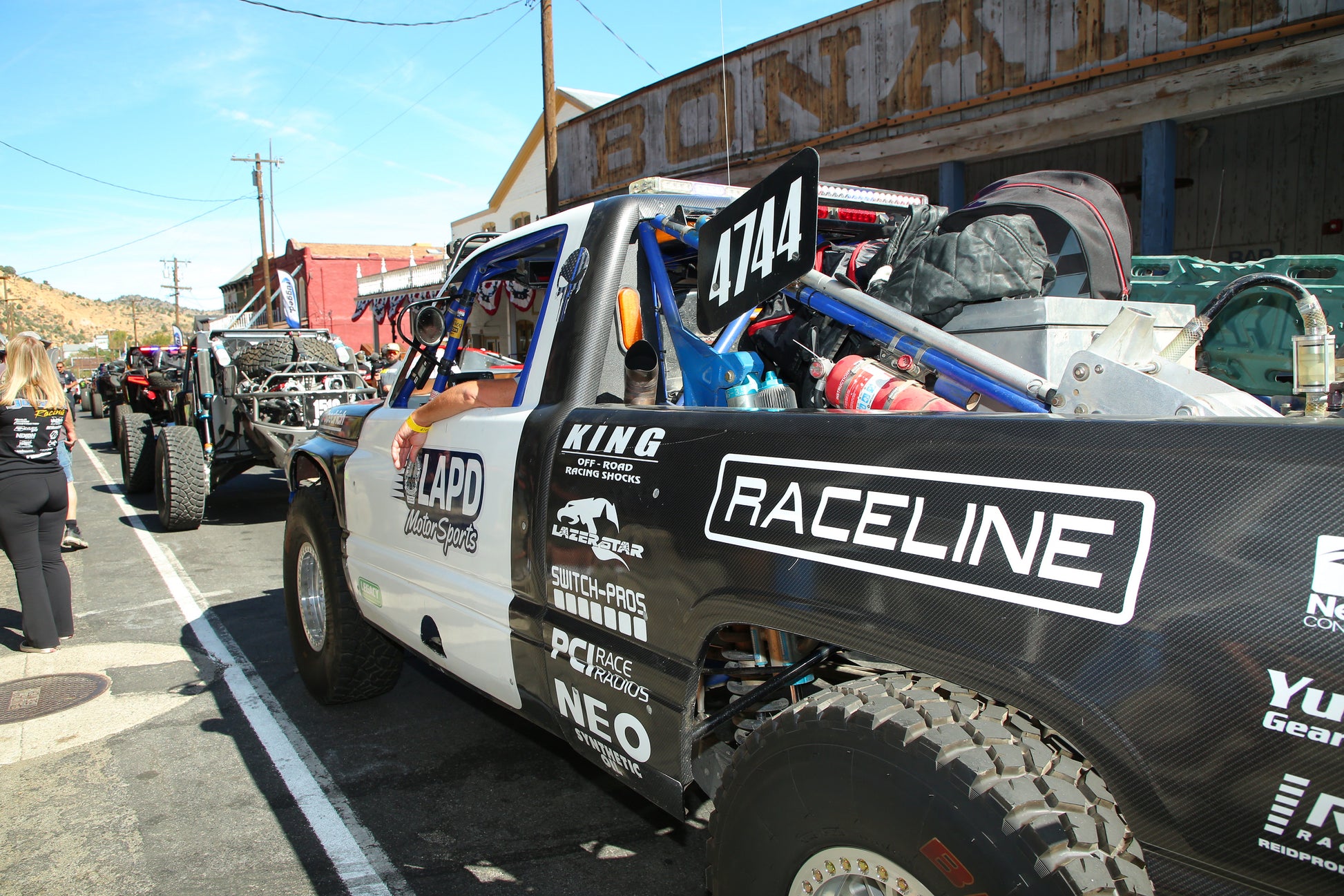 Truck with 'Raceline' branding on a street with other vehicles and people in the background.