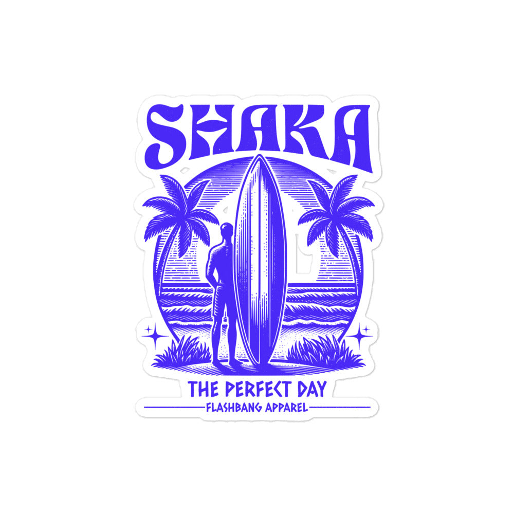 Sticker with a surfer holding a surfboard between palm trees and 'Shaka The Perfect Day' text on a white background.