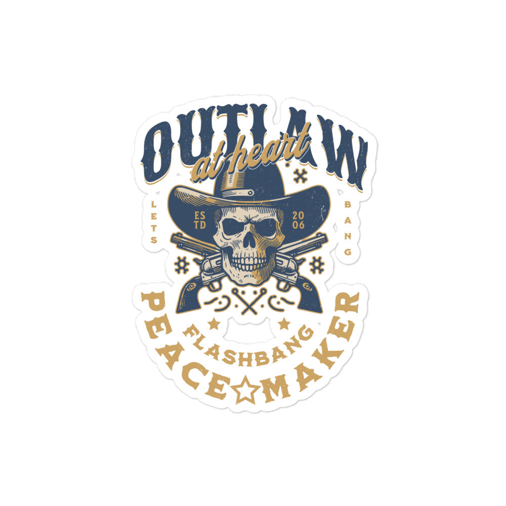 Sticker with a skull wearing a cowboy hat and crossed revolvers, text 'Outlaw at heart, peace maker', on a white background.