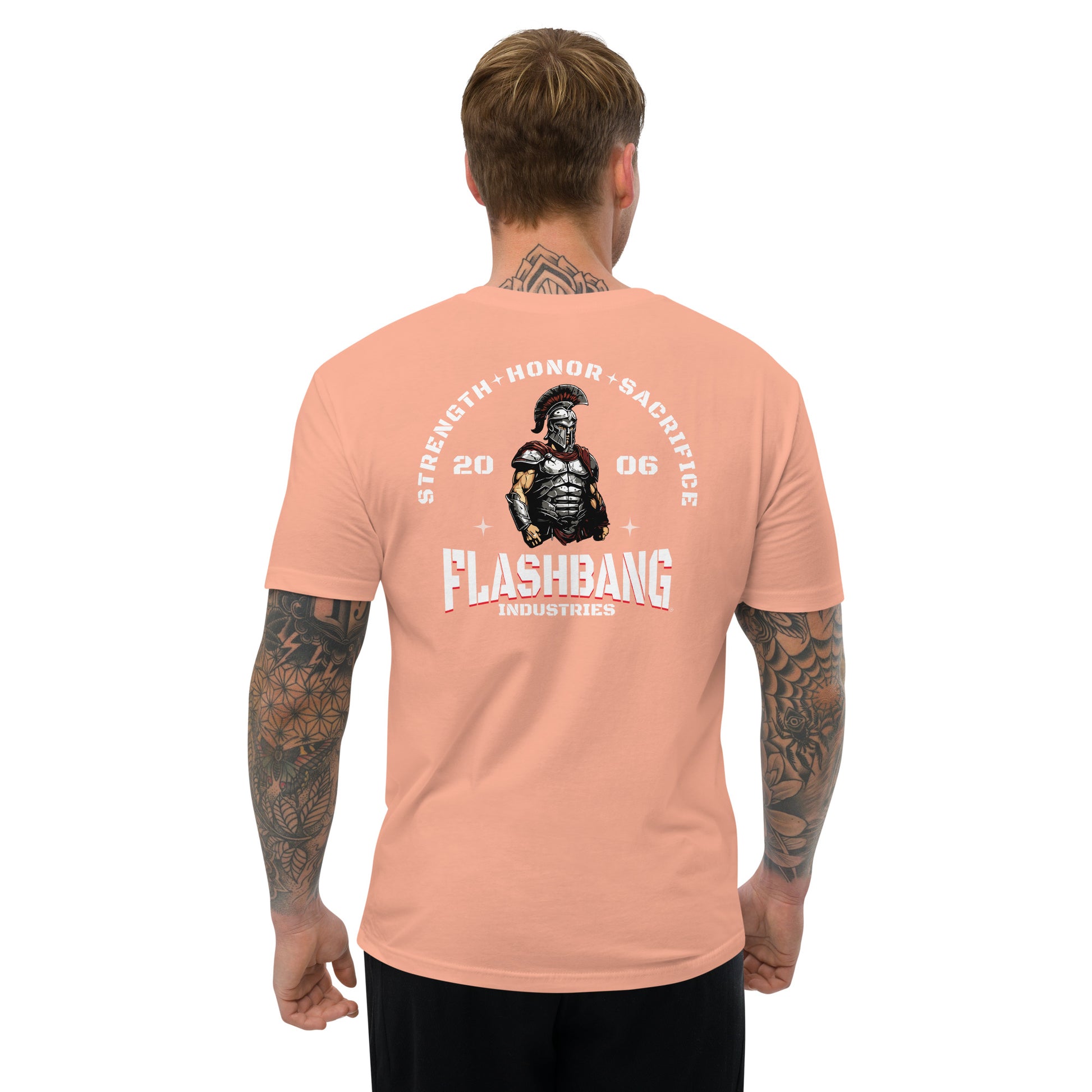Man wearing a peach t-shirt with 'Flashbang Industries' graphic on the back