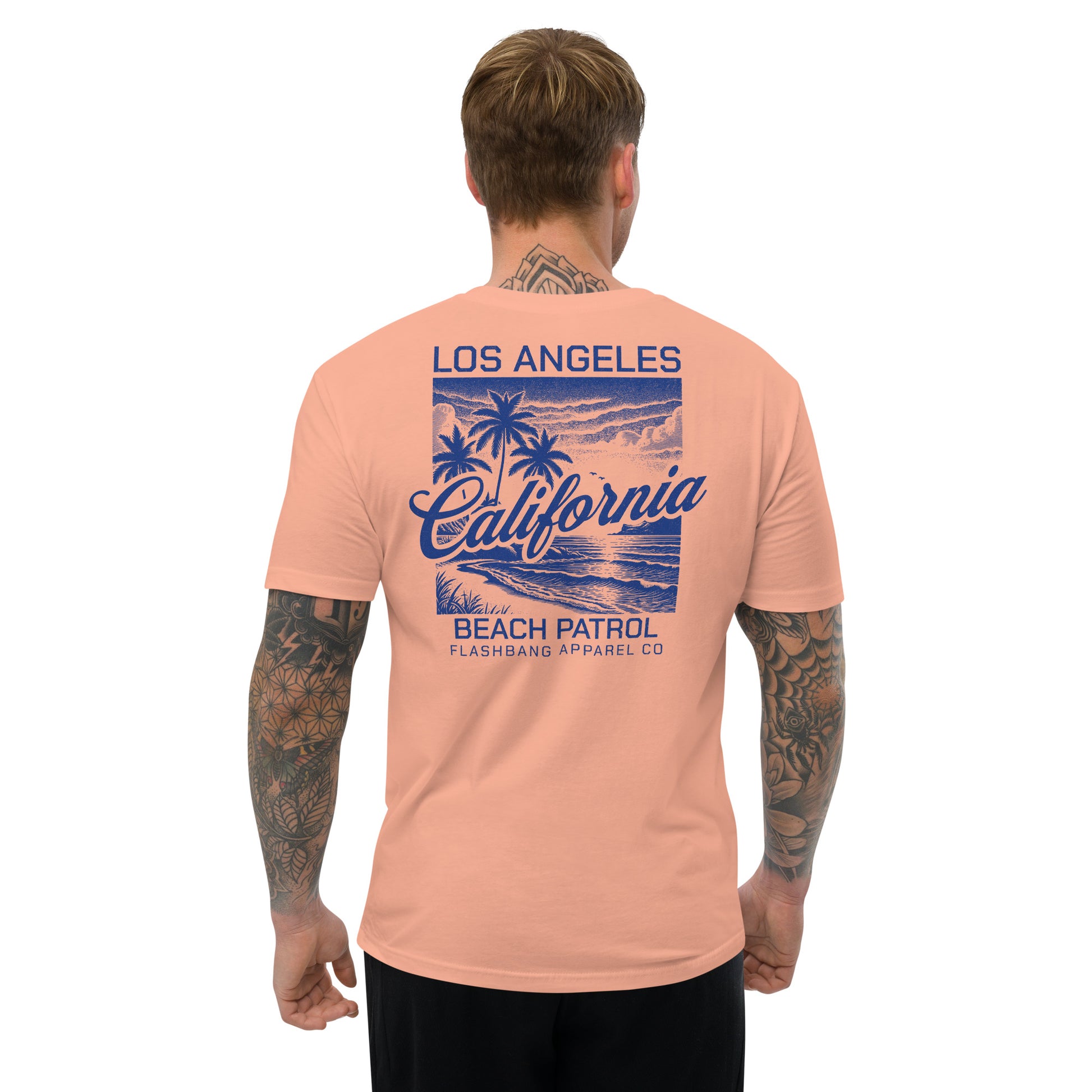 Man wearing a peach t-shirt with 'Los Angeles California Beach Patrol' design on the back.