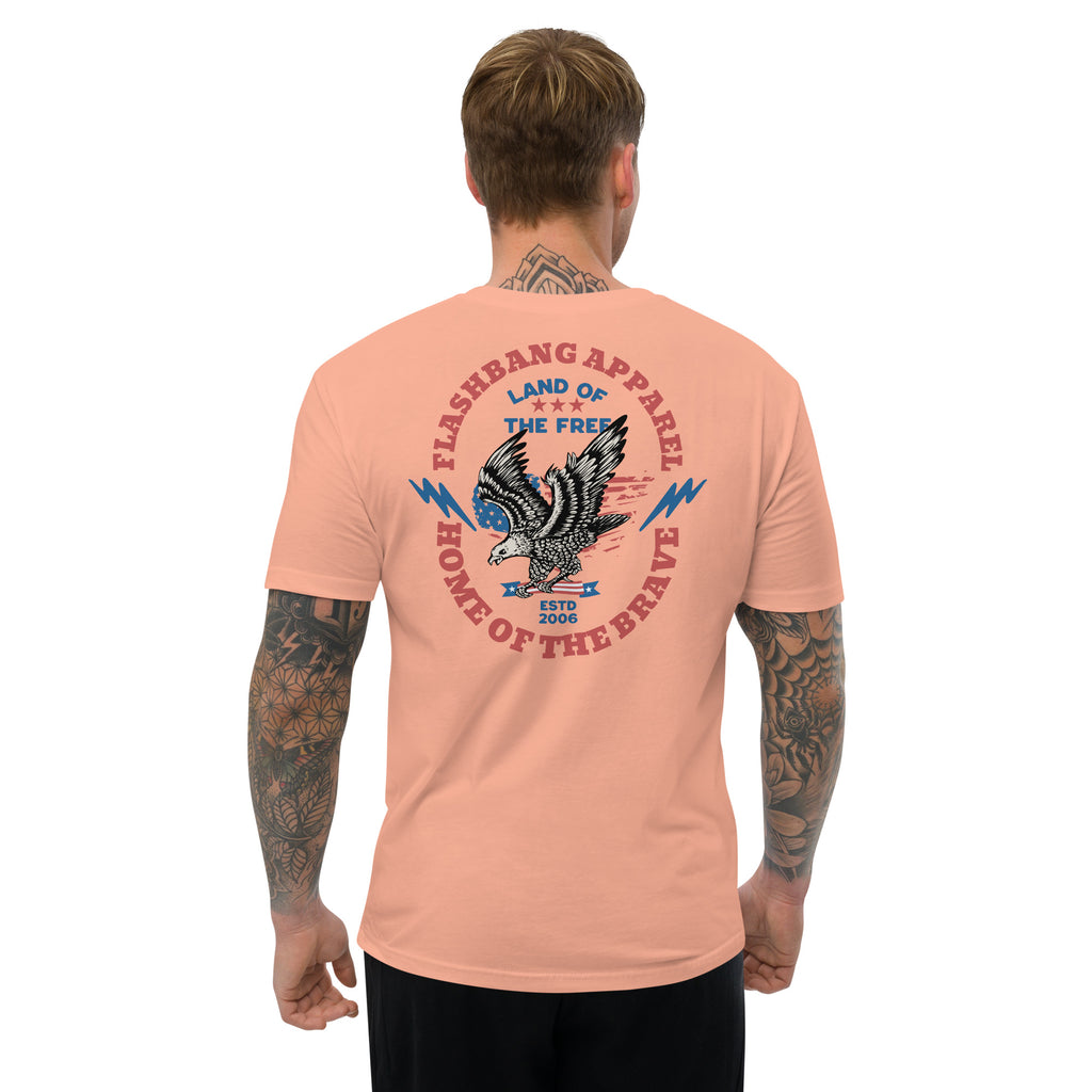 Man wearing a peach t-shirt with an eagle graphic and text on the back, on a white background