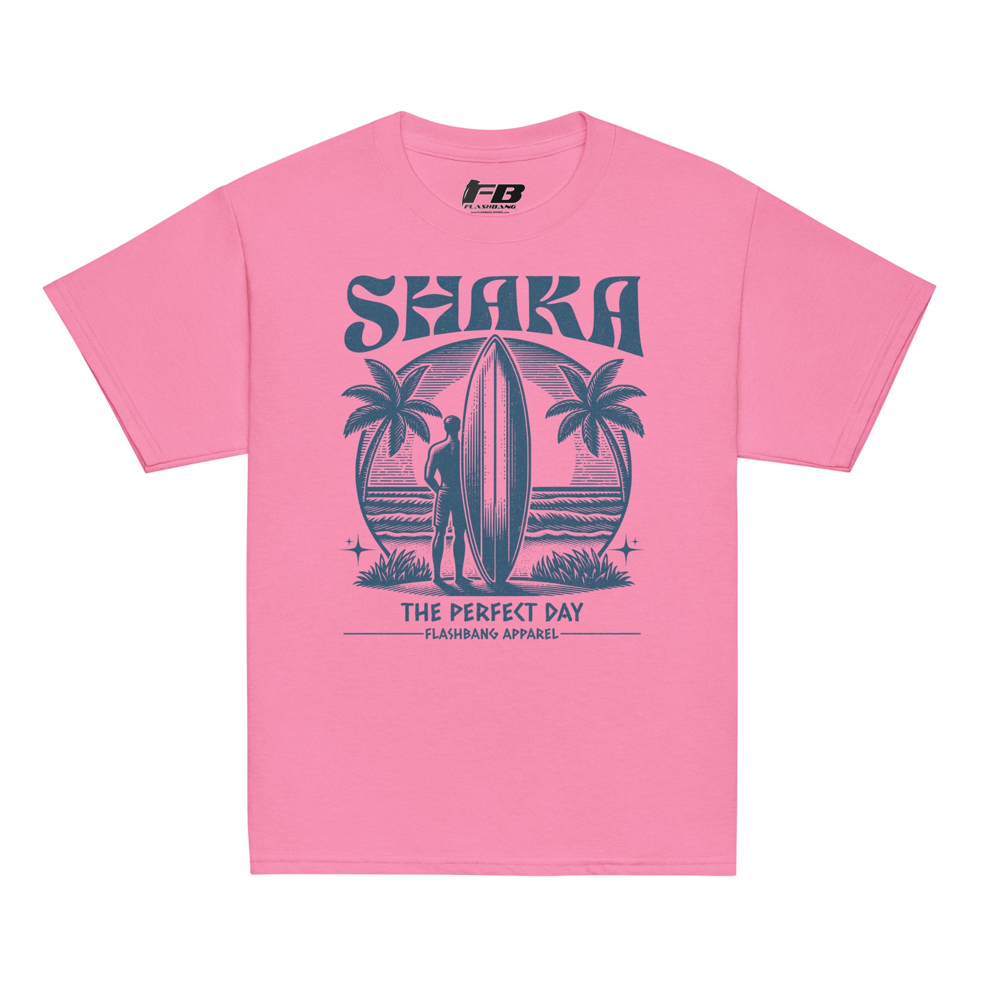 Pink t-shirt with a graphic design of a person with a surfboard and palm trees, featuring the text 'Shaka The Perfect Day' on a white background.